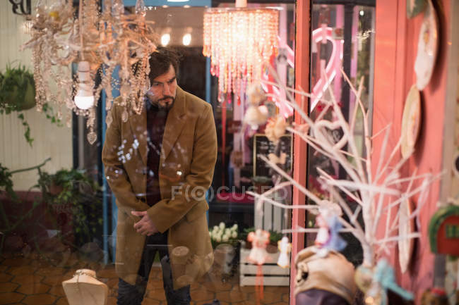 Man looking at chandeliers in vintage store — Stock Photo
