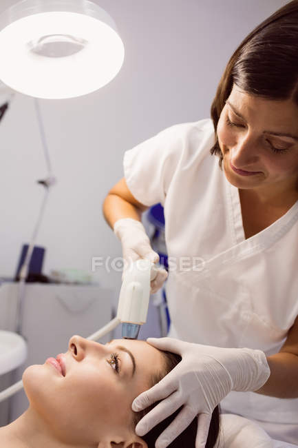 Medico che dà trattamento cosmetico al paziente femminile presso la clinica estetica — Foto stock