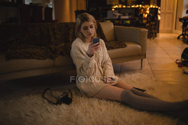 Frau benutzt Mobiltelefon im Sitzen — Stockfoto