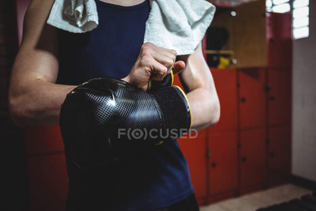 Boxer wearing boxing gloves in locker room at fitness studio — Stock Photo