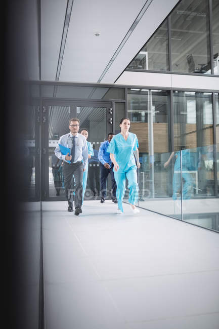 Médicos e enfermeiros correndo para emergência em instalações hospitalares — Fotografia de Stock