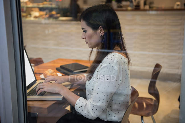 Schöne Geschäftsfrau mit Laptop im Café — Stockfoto