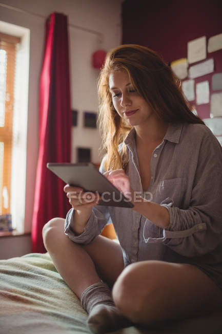 Усміхнена жінка використовує цифровий планшет у спальні вдома — стокове фото