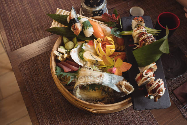 Sushi vari in piatto di sushi di bambù in ristorante — Foto stock