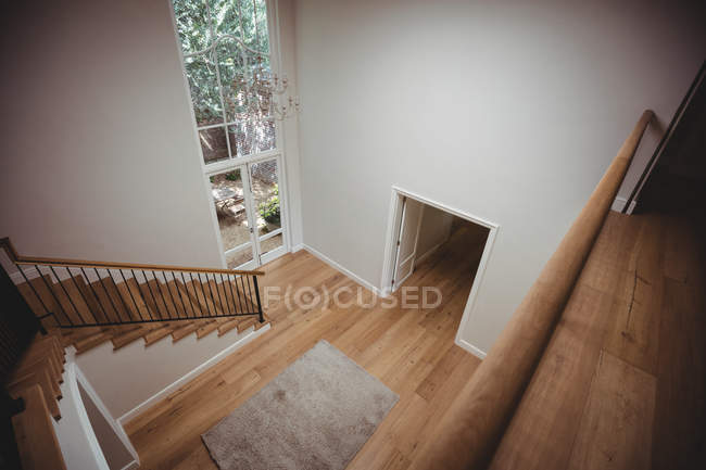 Интерьер дома с деревянным полом и лестницей с белыми стенами — стоковое фото