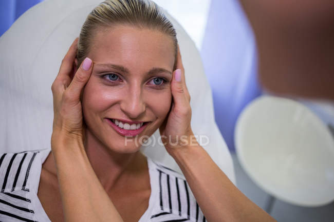 Médico examinando rosto paciente feminino para tratamento cosmético na clínica — Fotografia de Stock