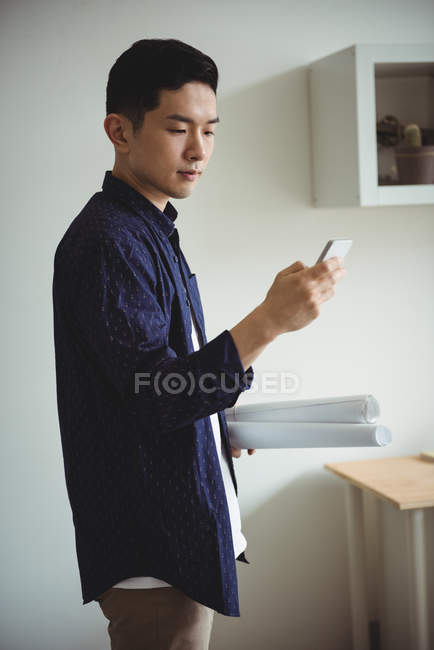 Geschäftsführender Angestellter mit Handy im Büro — Stockfoto