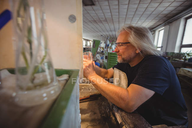 Glassblower polimento e moagem de um vidro em fábrica de sopro de vidro — Fotografia de Stock