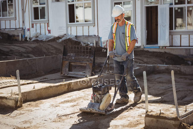 Travailleur de la construction nivellement du sol sur le chantier — Photo de stock