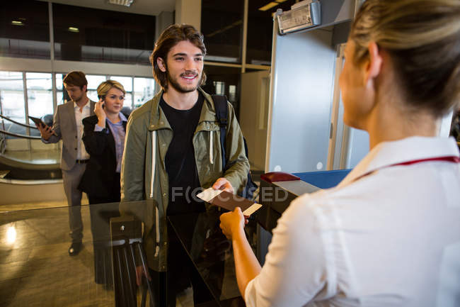 Чоловік в черзі отримує паспорт і посадковий талон в терміналі аеропорту — стокове фото
