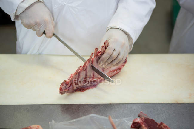 Close-up de carne de corte de açougueiro na fábrica de carne — Fotografia de Stock