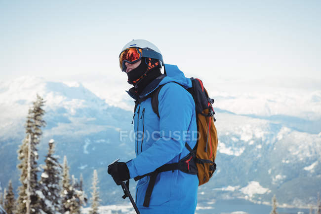 Esquiador em pé em montanhas cobertas de neve — Fotografia de Stock