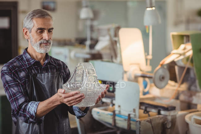 Ventilador que examina la cristalería en la fábrica de soplado de vidrio - foto de stock