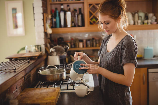 Mulher preparando café na cozinha em casa — Fotografia de Stock
