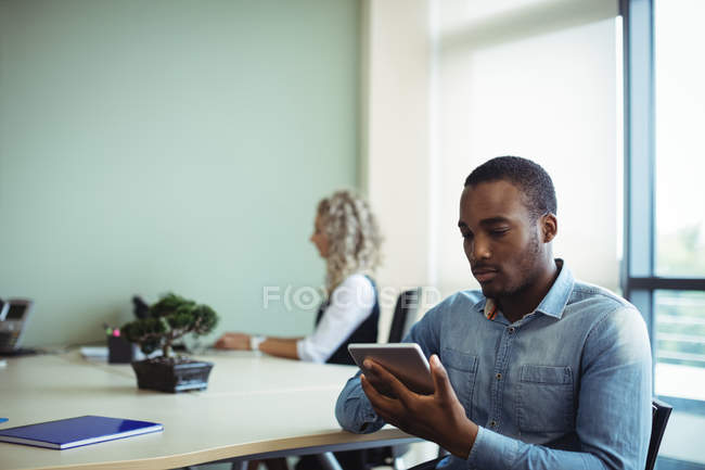 Young male business executive using digital tablet in office — Stock Photo