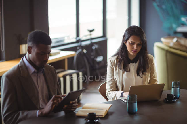 Бізнесмен і колега, використовуючи цифровий планшет і ноутбук в офісі — стокове фото