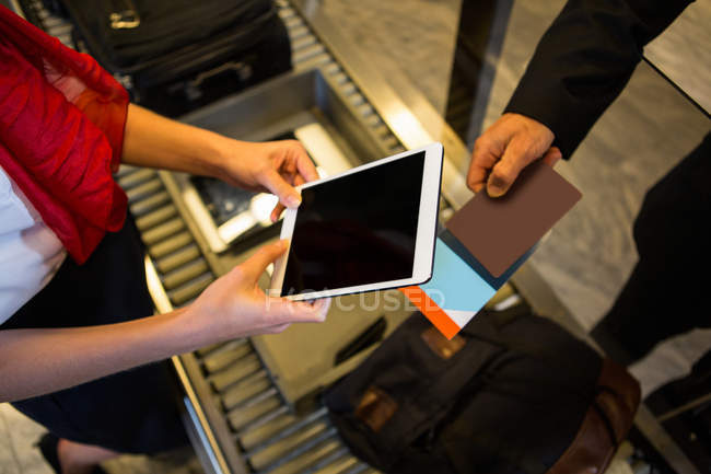 Gros plan de la femme scannant la carte d'embarquement avec une tablette numérique — Photo de stock