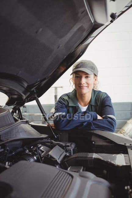 Ritratto di meccanico donna in piedi con le braccia incrociate in garage di riparazione — Foto stock