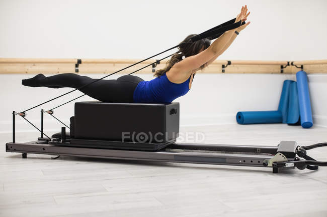 Frau trainiert an Reformer-Geräten im Fitnessstudio — Stockfoto