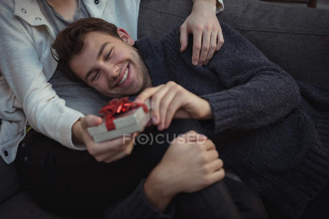 Close-up of happy gay couple holding festive gift — Stock Photo