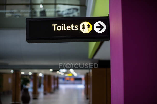 Primer plano del letrero de inodoro masculino y femenino en el aeropuerto - foto de stock