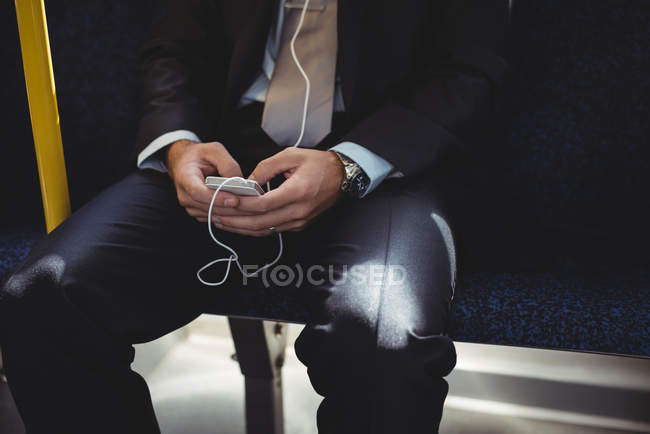 Mittelteil des Geschäftsmannes benutzt Handy während der Busfahrt — Stockfoto
