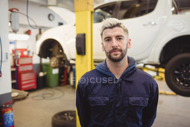 Портрет молодого механіка, що стоїть у ремонті гаража — стокове фото