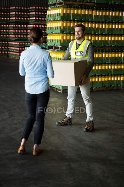 Visão traseira do gerente olhando para o trabalhador que trabalha no armazém — Fotografia de Stock