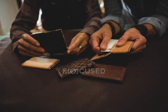 Kunsthandwerker diskutieren in Werkstatt über ein Blatt Leder — Stockfoto