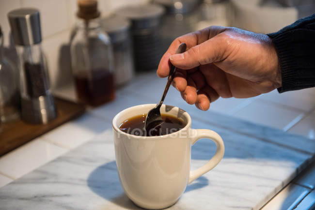 Uomo che prepara un caffè nero in cucina a casa — Foto stock