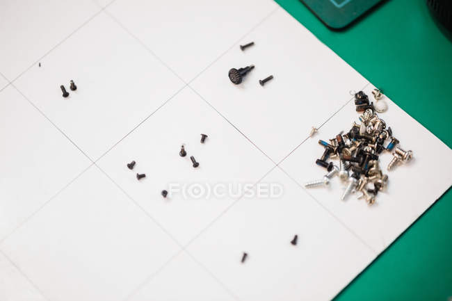 Nahaufnahme verschiedener Schrauben auf dem Tisch in einem Reparaturzentrum — Stockfoto