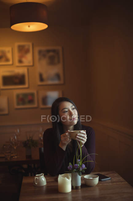 Thoughtful woman having cup of coffee in cafe — Stock Photo