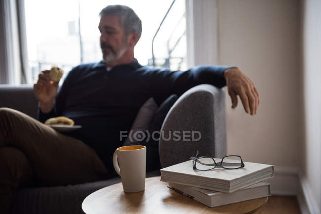 Man having sandwich in living room at home — Stock Photo