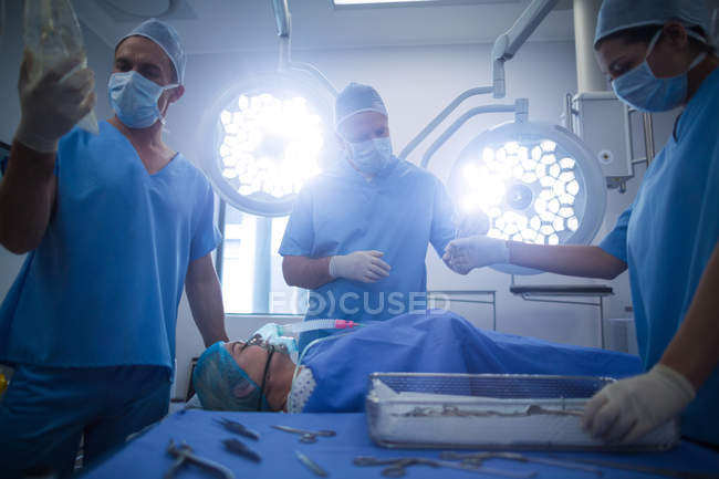 Grupo de cirurgiões que realizam operação em sala de operação no hospital — Fotografia de Stock