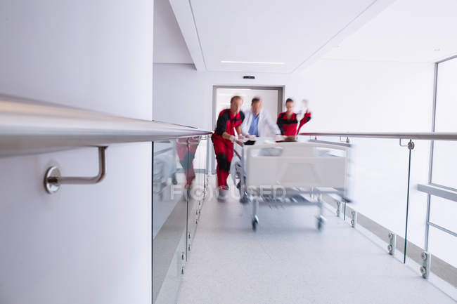 Врачи переносят неотложные носилки в коридоре больницы — стоковое фото