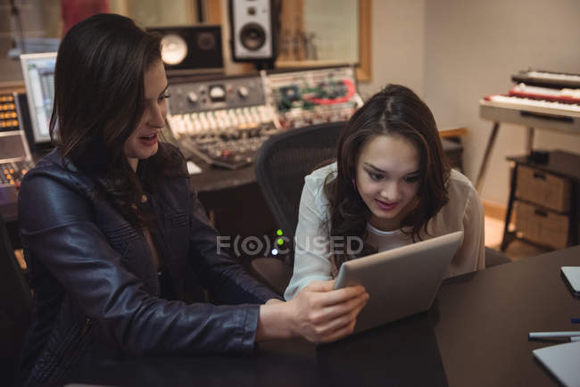 Engenheiros de áudio usando tablet digital em estúdio de gravação — Fotografia de Stock