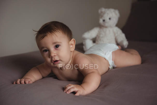 Симпатична дитина лежить на животику в спальні вдома — стокове фото