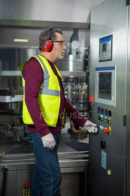 Trabalhador manual sério analisando máquinas na fábrica — Fotografia de Stock