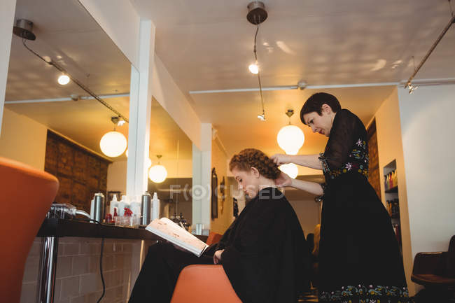 Friseurin stylt Kunden Haare im Salon — Stockfoto