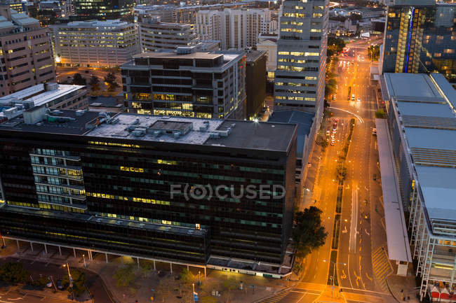 Aerial view of street and office buildings in business district at night — Stock Photo