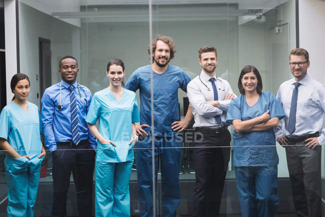 Портрет улыбающихся врачей, стоящих вместе в коридоре больницы — стоковое фото
