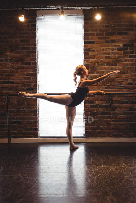 Bailarina praticando dança de balé no barre — Fotografia de Stock