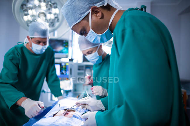 Groupe de chirurgiens effectuant une opération dans le théâtre d'opération de l'hôpital — Photo de stock