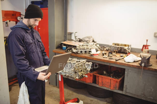 Механік, використовуючи ноутбук у ремонт гаража — стокове фото