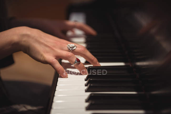 Mani di donna che suona un pianoforte in studio di musica — Foto stock