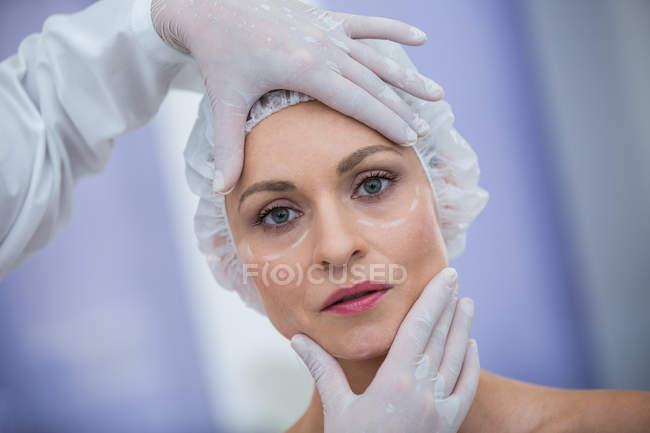 Доктор вивчення жіноче обличчя пацієнта для косметичне лікування в клініці — стокове фото