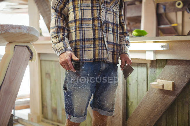 Mittelteil eines Mannes mit Werkzeugen in der Surfbrett-Werkstatt — Stockfoto