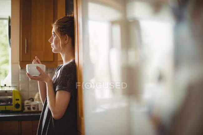 Mulher atenciosa tomando café na cozinha em casa — Fotografia de Stock