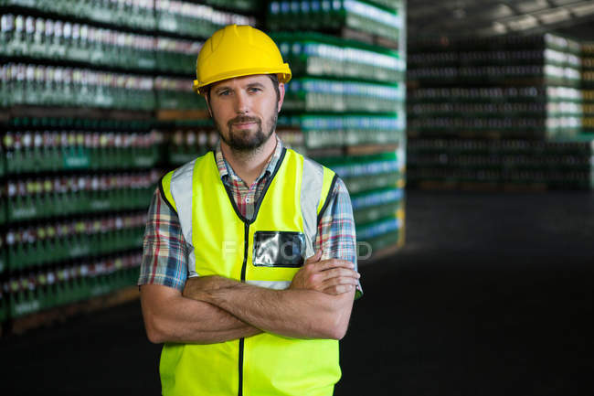 Portrait d'un jeune ouvrier debout dans un entrepôt — Photo de stock