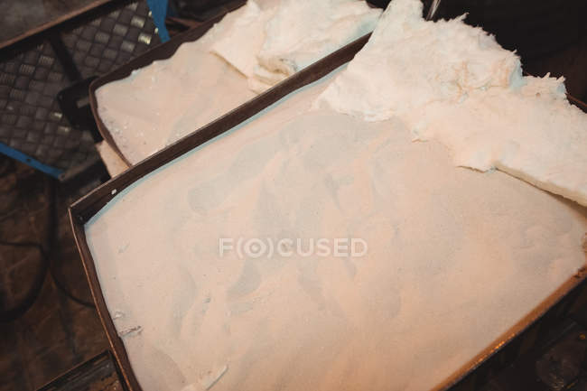 Крупним планом пісок у металевій тарі на скляній фабриці — стокове фото